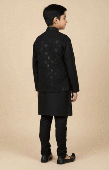 The same boy shown from the back, wearing a black kurta pajama and embroidered jacket.